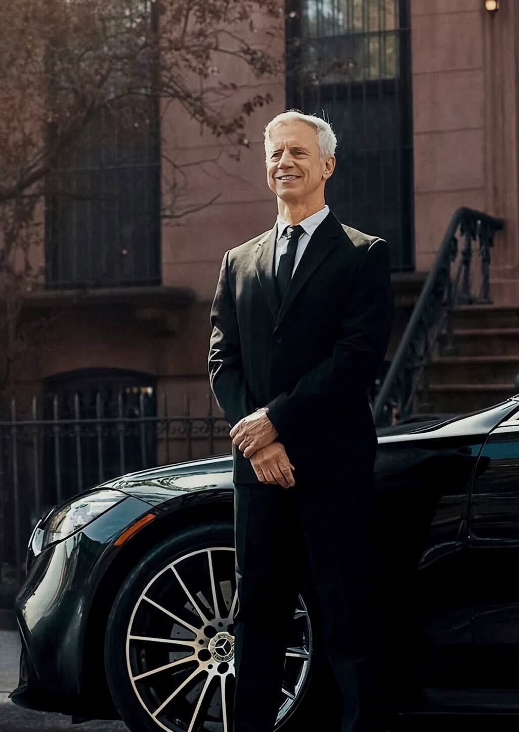 Executive chauffeur standing next to a car