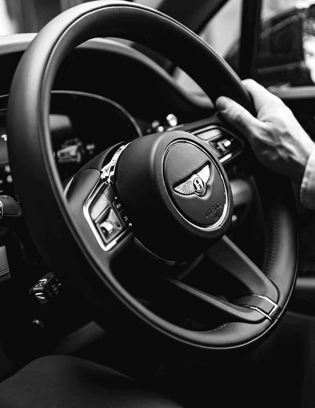Chauffeur hands on the steering wheel of a Bentley